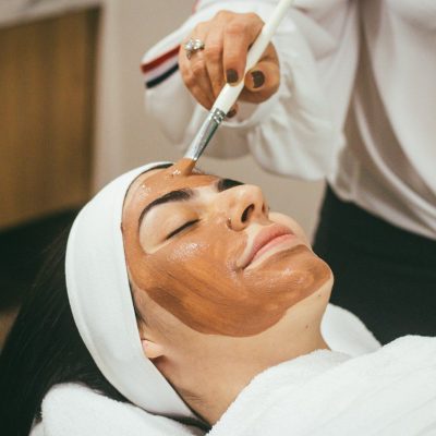 A woman receiving a facial mask treatment