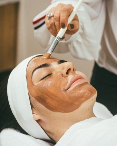 A woman receiving a facial mask treatment