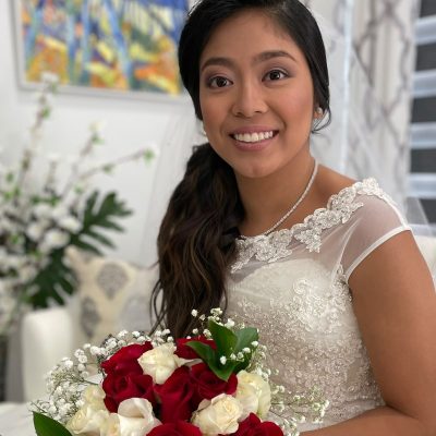 Bride with a side-swept hairstyle holding a bouquet of roses