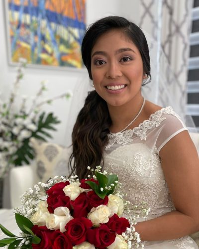 Bride with a side-swept hairstyle holding a bouquet of roses