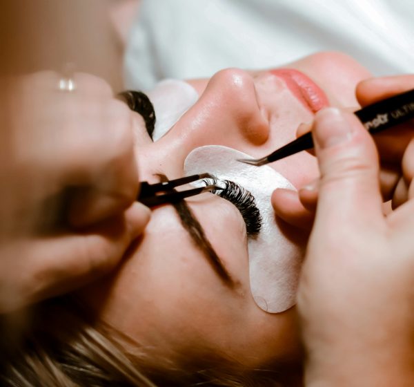 Eyelash extensions being applied with tweezers