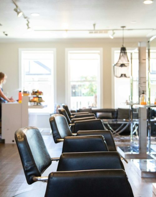 Stylist standing beside salon chairs