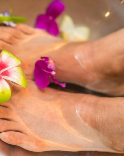 Feet soaking in a bath with flowers