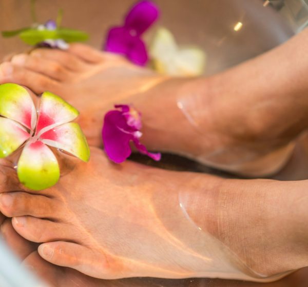 Feet soaking in a bath with flowers